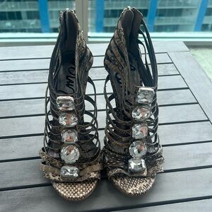 Heels with silver stones in the front part of the shoes with snake print
